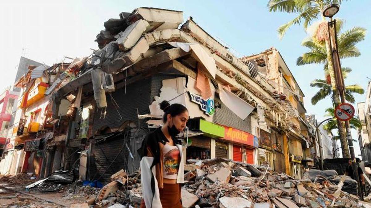 Una dona camina davant d'un edifici en runes després del terratrèmol a Pereira, Colòmbia