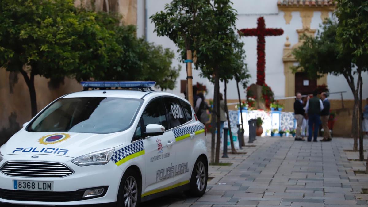 Una patrulla de la Policía Local en el entorno de una de las cruces de mayo de Córdoba.