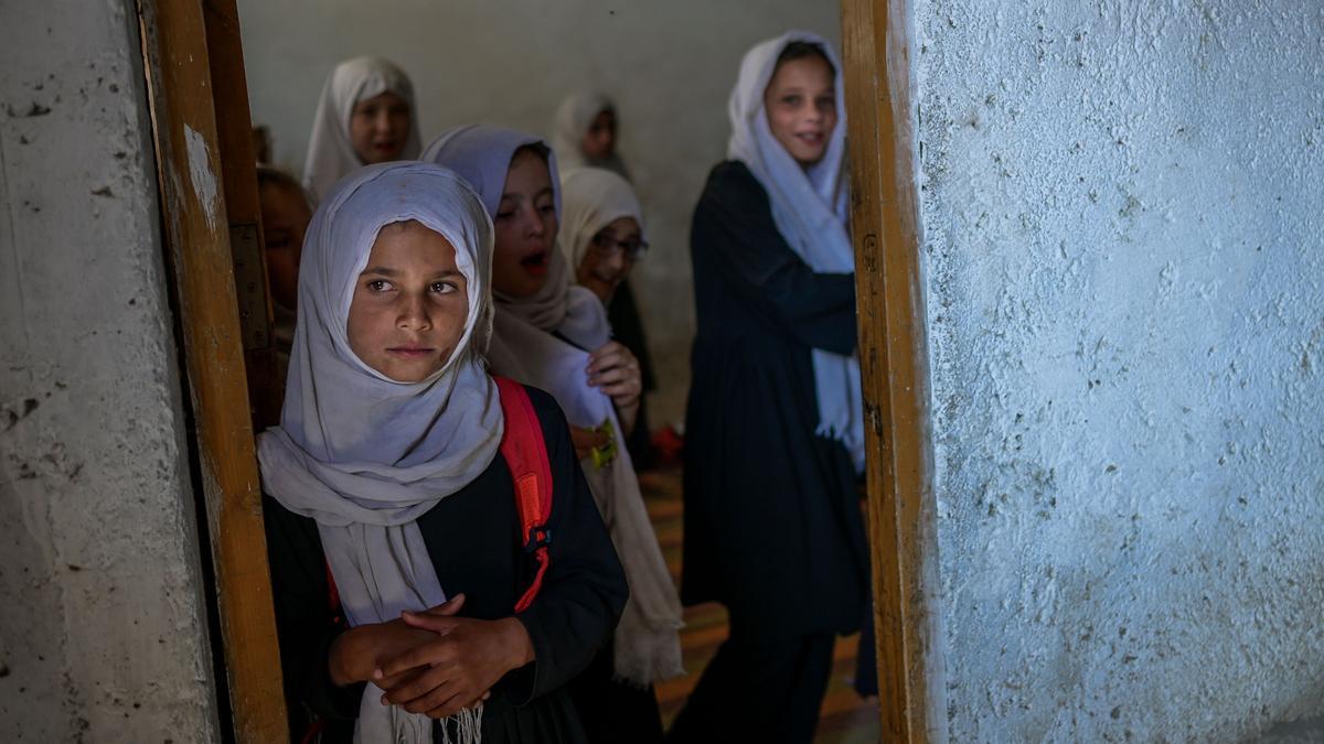 TOPSHOT - School girls gather at their class after arriving at a gender-segregated school in Kabul on September 15, 2021. (Photo by BULENT KILIC / AFP)
