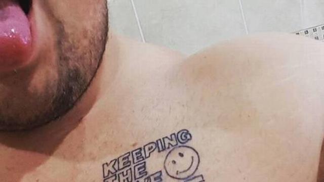 Un joven muestra el tatuaje que se hizo durante sus vacaciones.