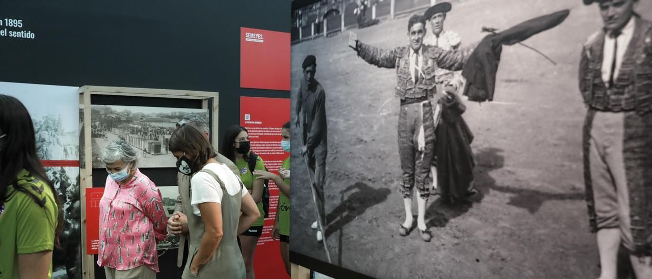 Ana González pasa delante de una fotografía de toros tomada en Gijón.