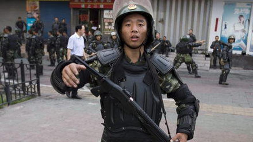 Policías antidisturbios se preparan, en las calles de Urumqi en la provincia de Xingiang (China). El número oficial de muertos en los incidentes que comenzaron el 5 de julio se elevó a 184, con 137 de ellos chinos Han, 46 étnicos Uighurs y un étnico Hui