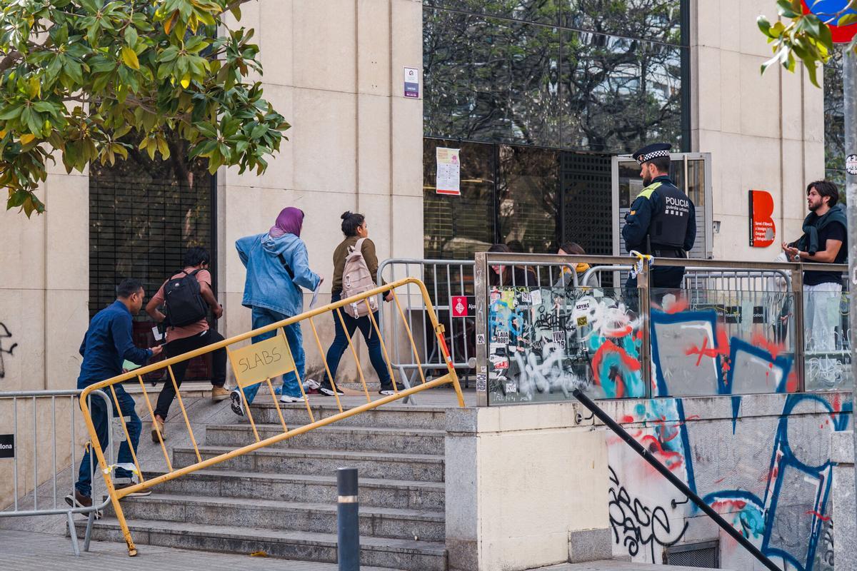 Caos y una larga cola de personas que esperan regularizar su situación en España en la Oficina de Benestar Social i Família de Barcelona-Sants/Eixample.