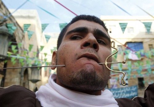 A member of a Lebanese Sufi Muslim group with his mouth pierced with a skewer takes part in a ritual to commemorate the birth of Prophet Mohammed at the port city of Sidon