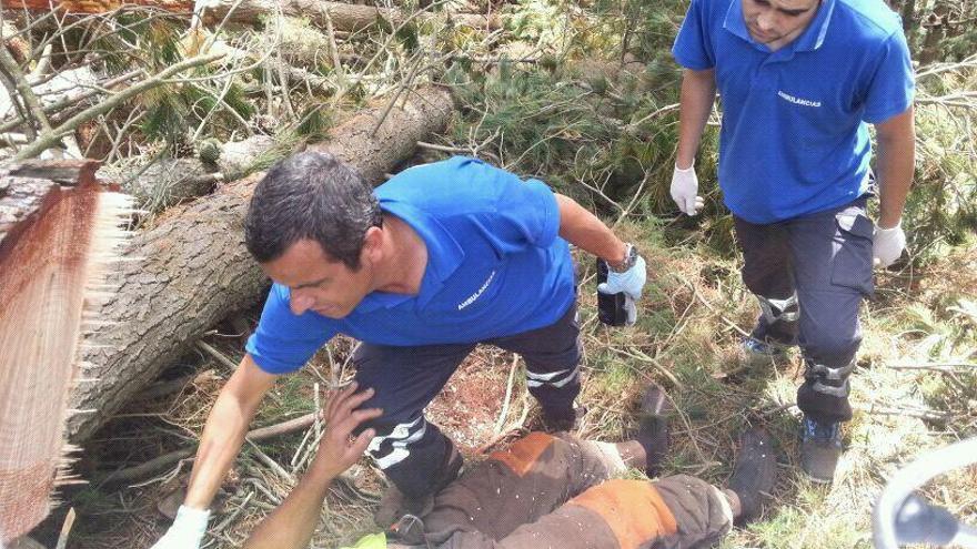 Dos sanitarios atienden a un leñador herido en Taramundi.