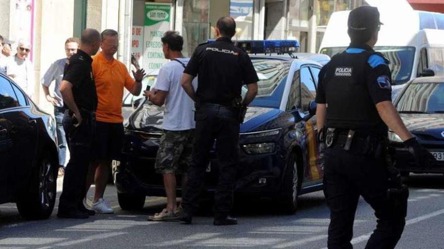 Los policías conversan con unos hombres tras el traslado del detenido al centro de salud. // FdV