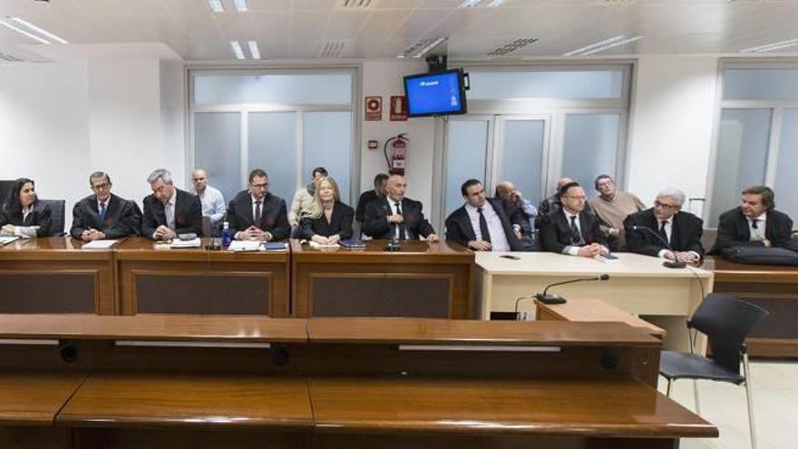 Los siete acusados tras sus abogados durante el juicio por el asesinato.