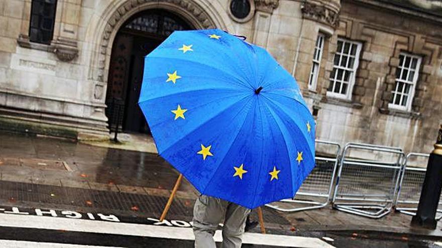 Un ciutadà es protegeix de la pluja, a Londres, amb un paraigües «europeista».