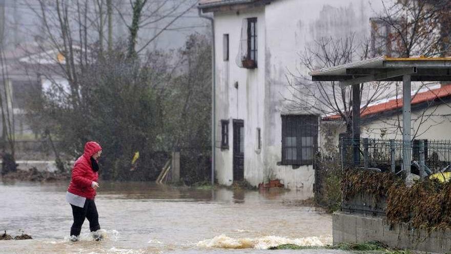 Una vecina, en la zona de Puente d&#039;Arcu, en Laviana, inundada el pasado 24 de enero.