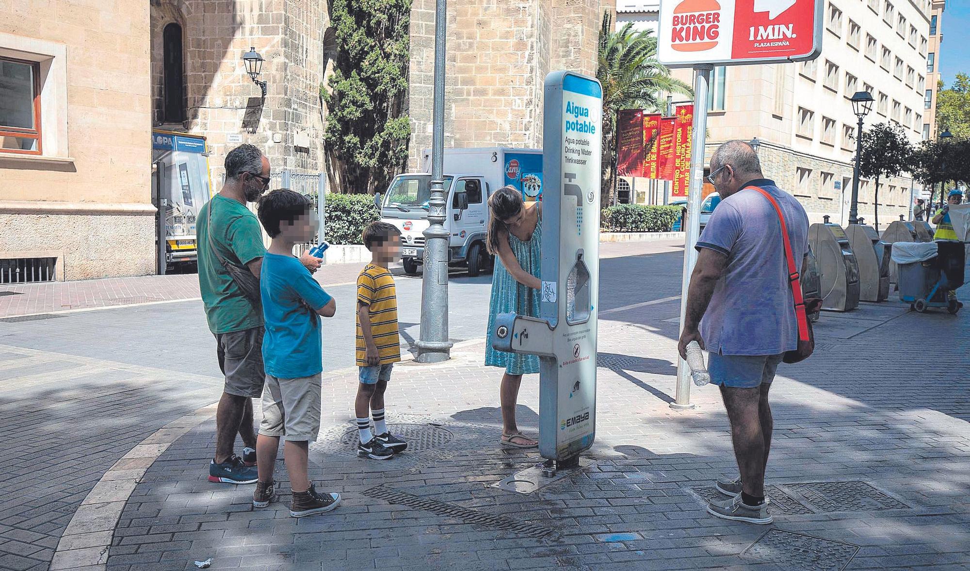 Ciudadanos usan el dispensador de agua cercano a plaza España.