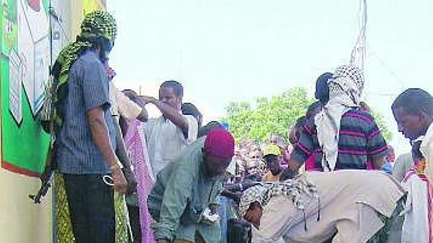 Ciudadanos somalíes cubren con telas y cartones algunos cadáveres.