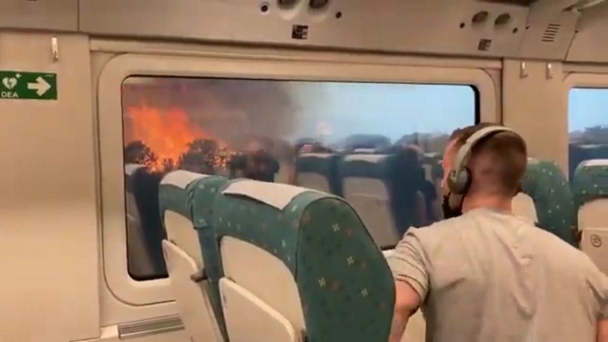 Pasajeros observan el incendio desde el interior del tren.