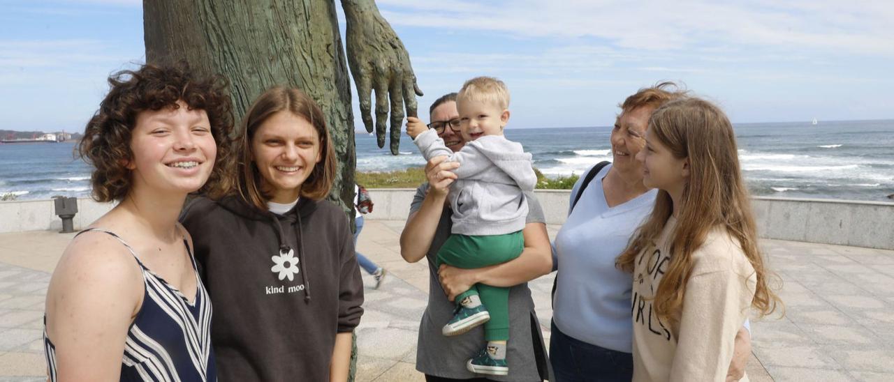 Por la izquierda, Kristina Tyshchenko, Masha Pavlovska, Lilia Katrecko con su bebé Mark, Halina Grischenko y Oksana Tyshchenko, junto a la estatua de «La madre del emigrante», en Gijón.