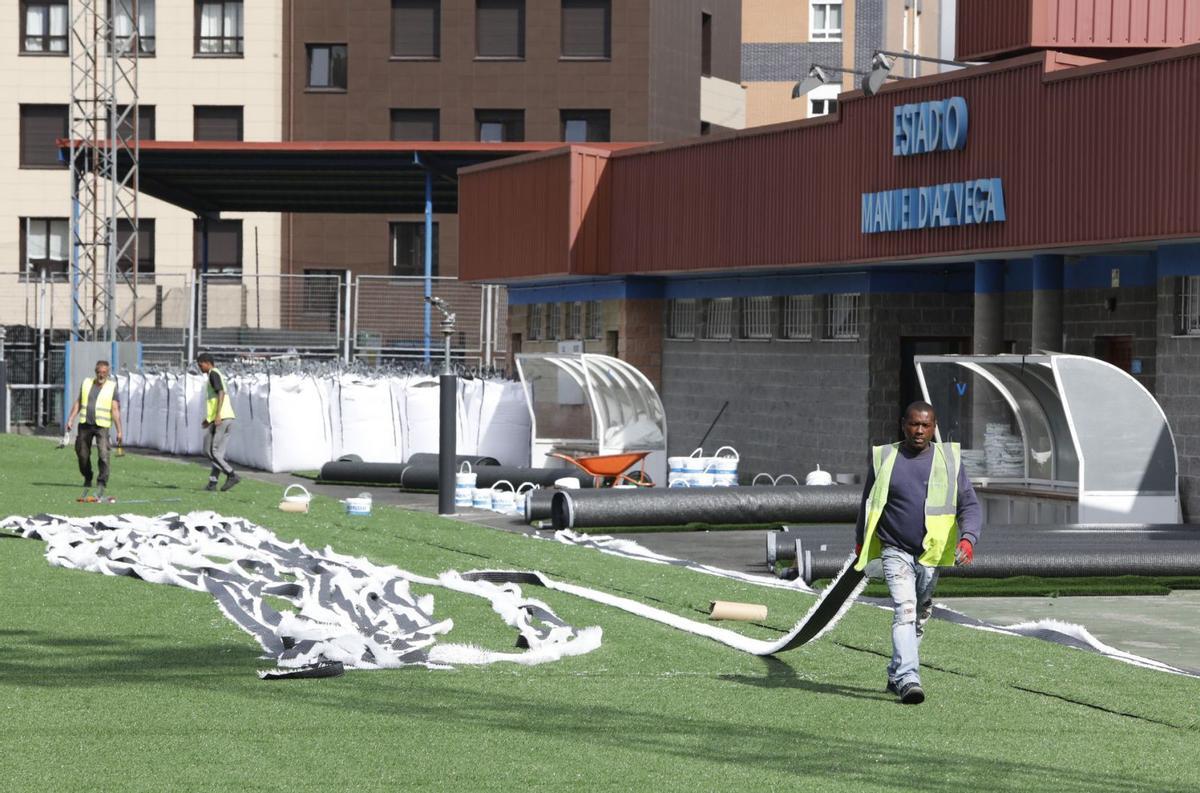 Operarios trabajando en el Díaz-Vega ayer, con el nuevo césped ya extendido sobre el terreno. | Luisma Murias