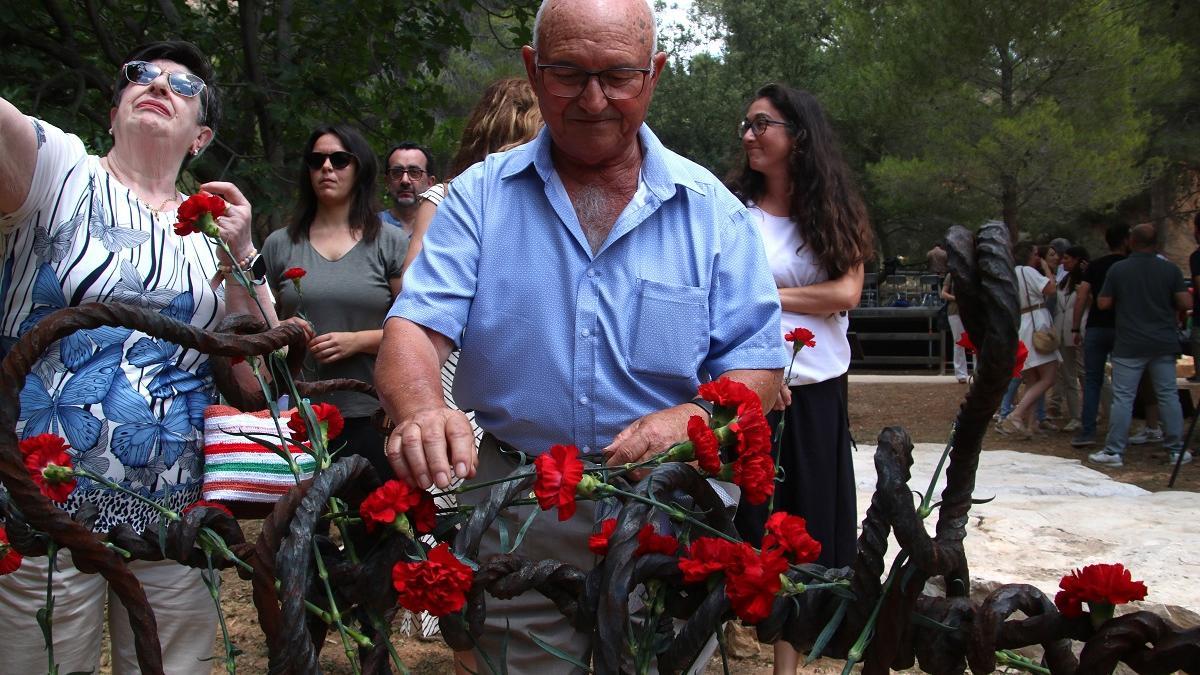 Un hombre deposita una flor en el monolito en Prat de Comte para recordar a los deportados