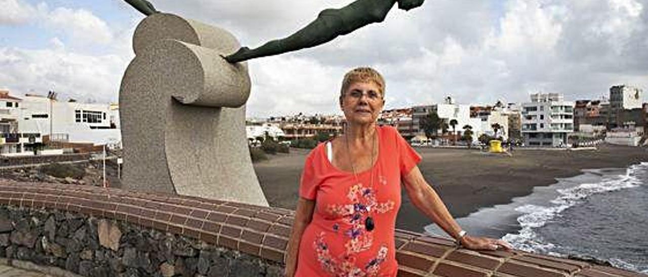 Elena Richau, vecina de La Garita, junto a la estatua de las nadadoras en la playa del barrio.