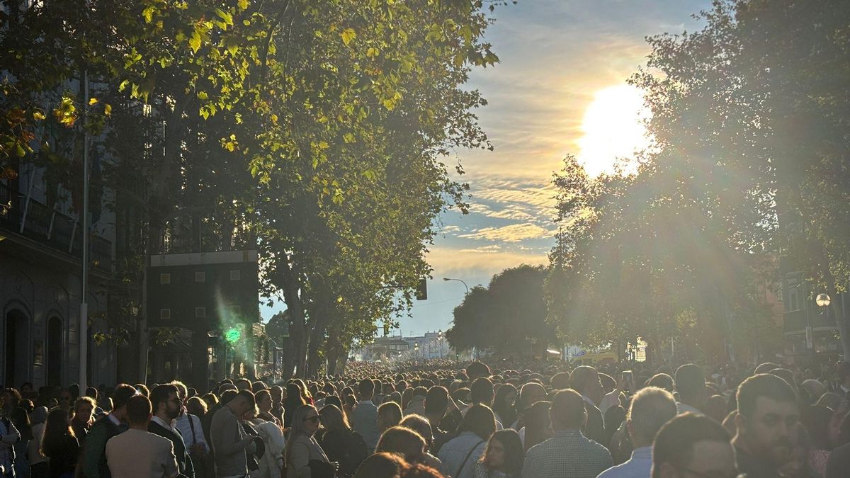 El ambiente en Reyes Católicos esperando a la Esperanza de Triana que termina de cruzar el Puente de Isabel II en estos instantes.