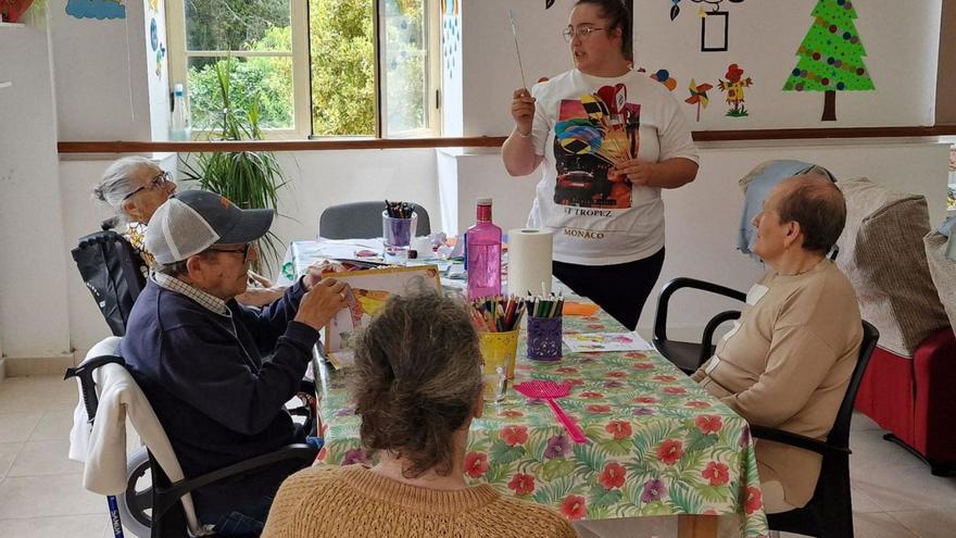 Un grupo de vecinas y vecinos de Cee en la casa do mayor de Carbaliza, con su coordinadora / colaxe