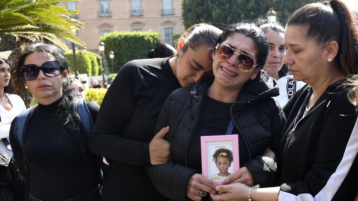 Ramona llora, arropada por sus familiares y sosteniendo una foto de la pequeña Nadia, el día después del crimen de la niña en la Glorieta de Murcia.