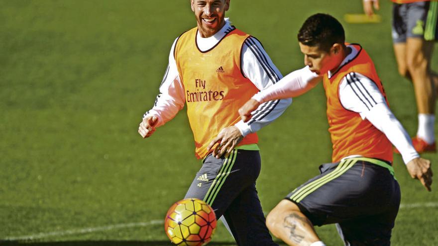 James golpea el balón en presencia de Ramos durante el entrenamiento de ayer del Madrid en Valdebebas. efe