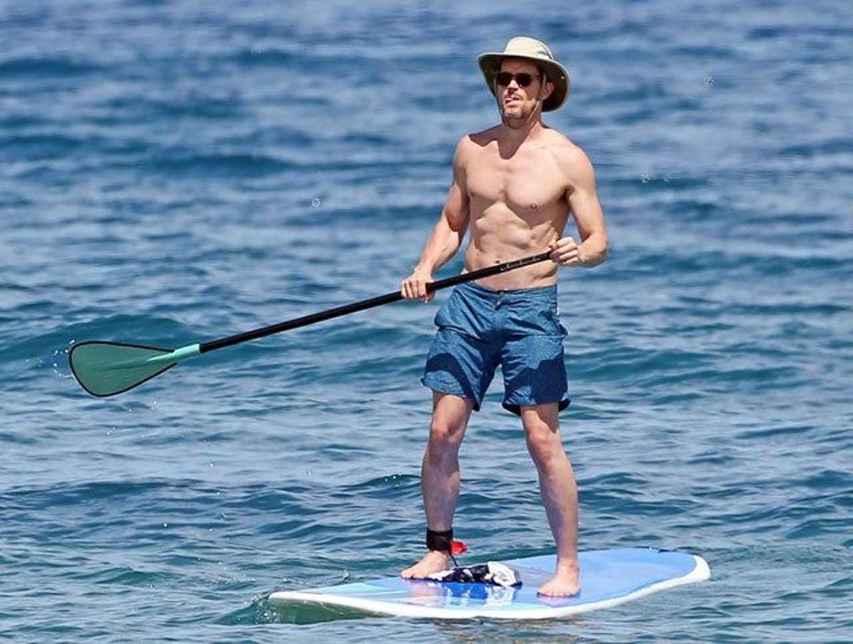 Matt Bomer de pie haciendo paddle surf