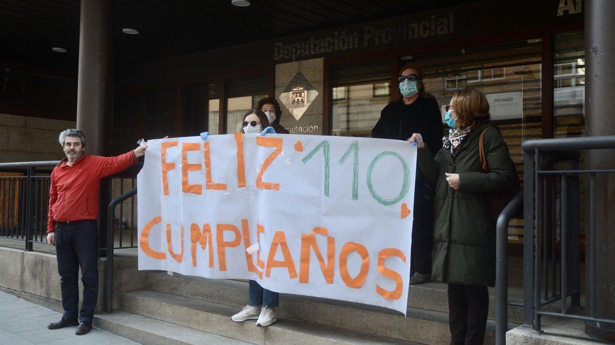 Familiares felicitando a Lulú con una pancarta frente a su casa.