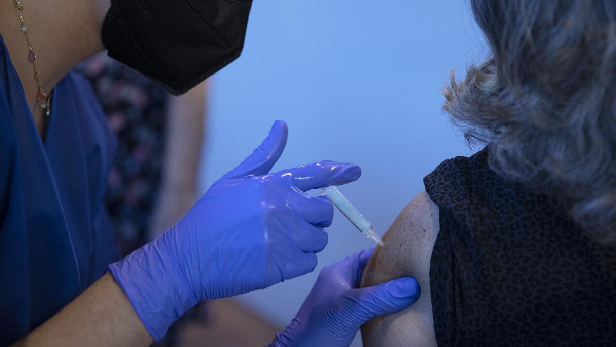 Una mujer recibe una vacuna frente al COVID.