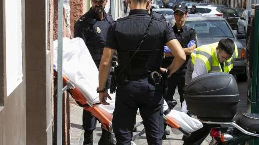 Los forenses sacan del edificio en el que se produjo el crimen el cuerpo de la víctima de Las Palmas, ayer.