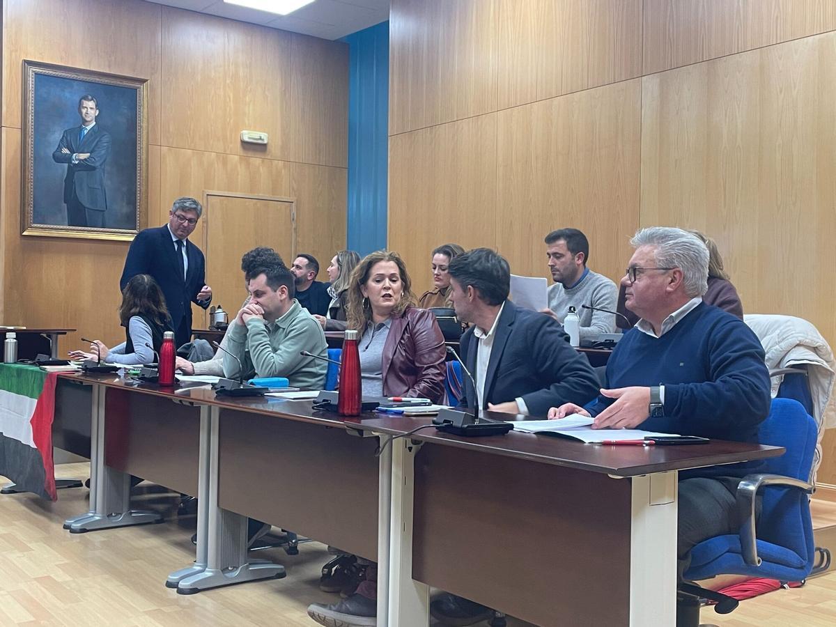 El alcalde de Puente Genil, de pie, se dirige a una concejala instantes antes del pleno.