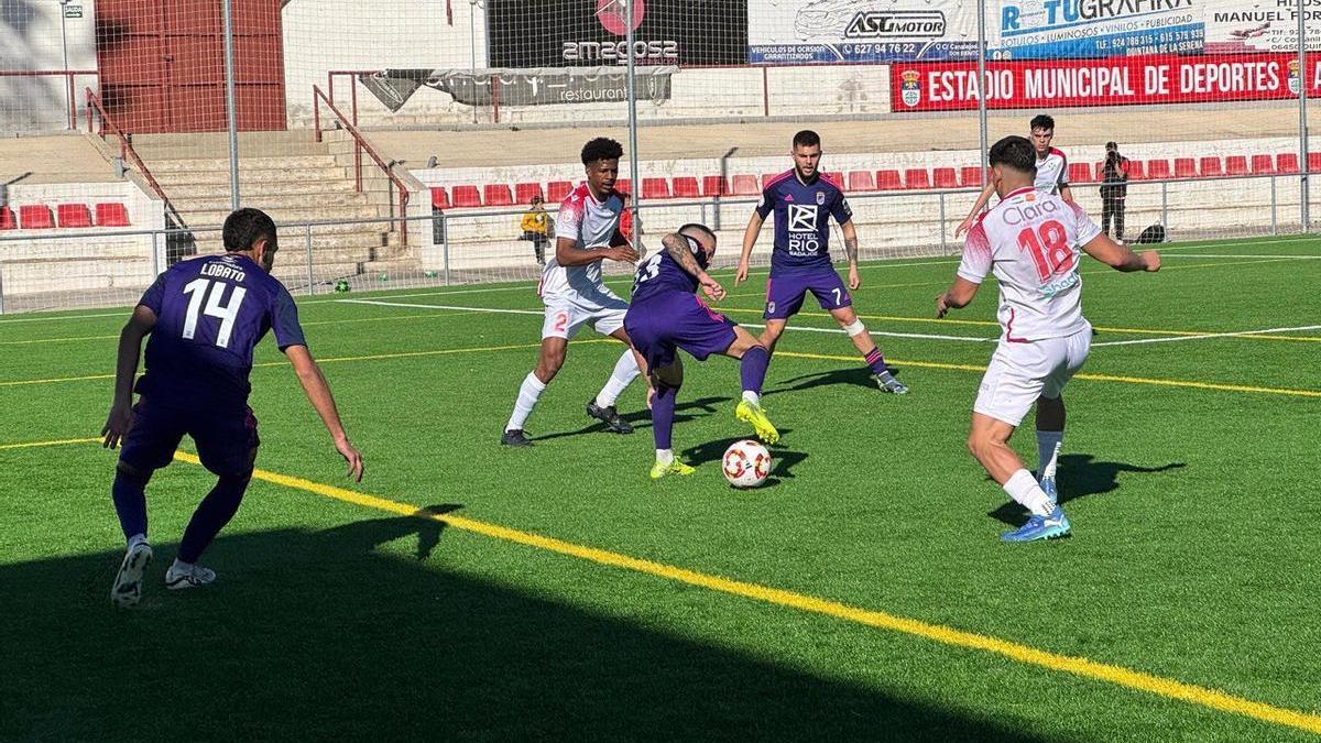 Santi Luque protege el cuero entre varios jugadores del Castuera.