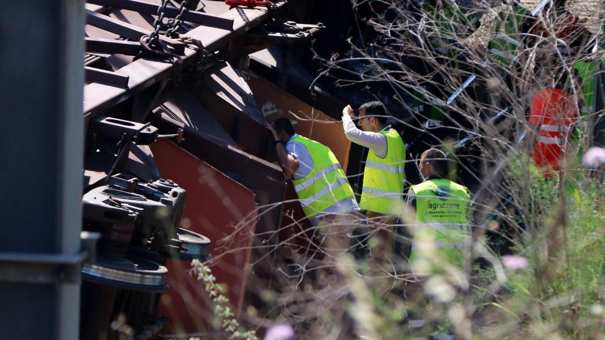 Diversos operaris inspeccionen el tren de mercaderies accidentat a Sant Boi