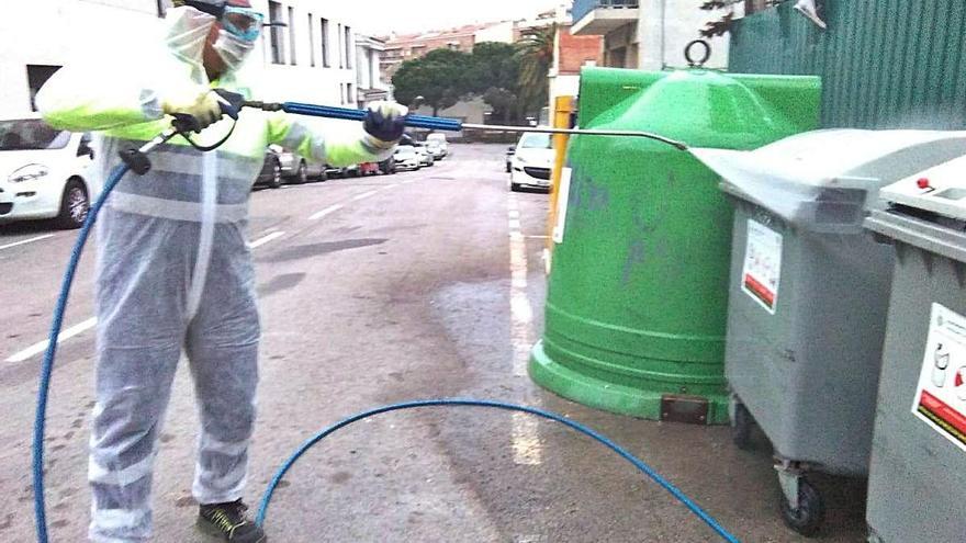 Un treballador realitzant tasques de desinfecció en un contenidor.