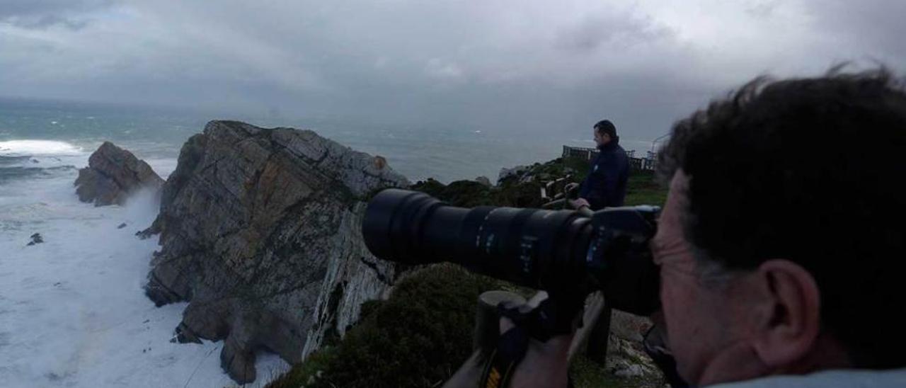 Vecinos fotografiando el paisaje del Cabo Peñas.