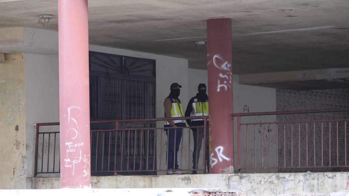 Dos agentes custodian el portal de uno de los edificios.