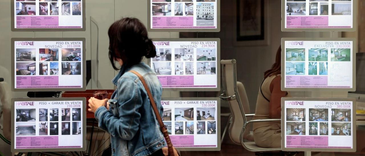 Una mujer observa los anuncios de una inmobiliaria.