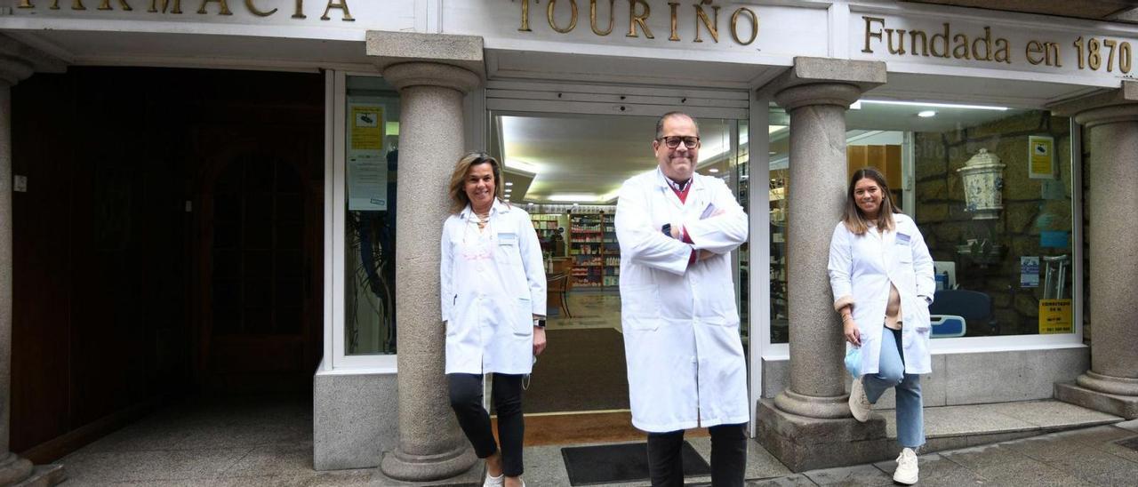 El matrimonio formado por Ana y Enrique, con su hija Ana, en la fachada del histórico establecimiento.