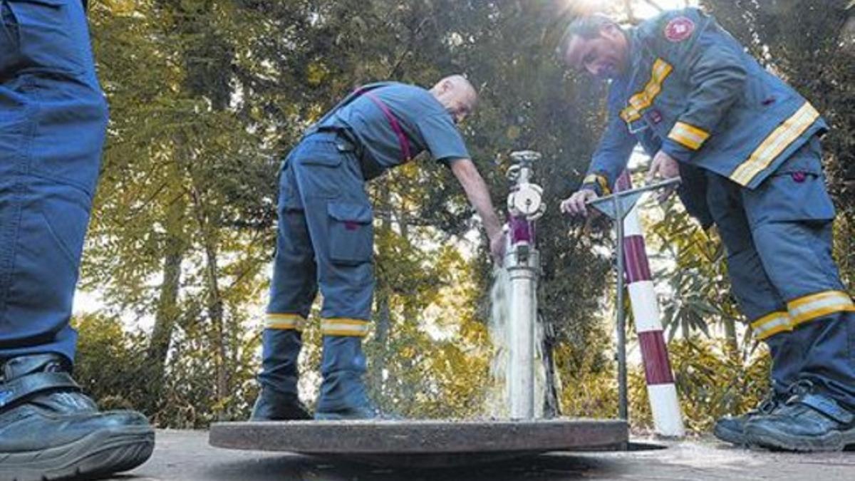 Bomberos del minicuartel de Vallvidrera comprueban el estado de una boca de riego, la semana pasada.