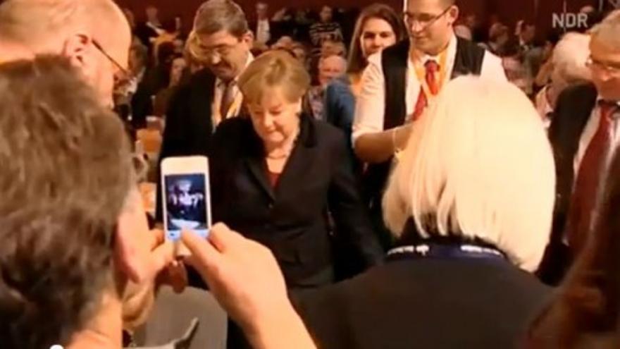 Un camarero torpe vierte cinco cervezas sobre Merkel