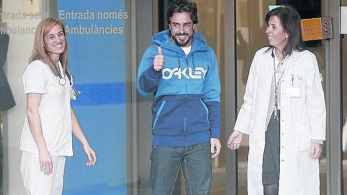 Alonso sonríe y muestra el pulgar a la prensa, ayer a la salida del Hospital General de Catalunya.