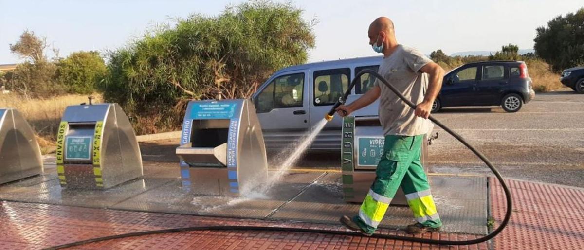 Un operario de la empresa limpia el entorno de unos contenedores soterrados en Formentera