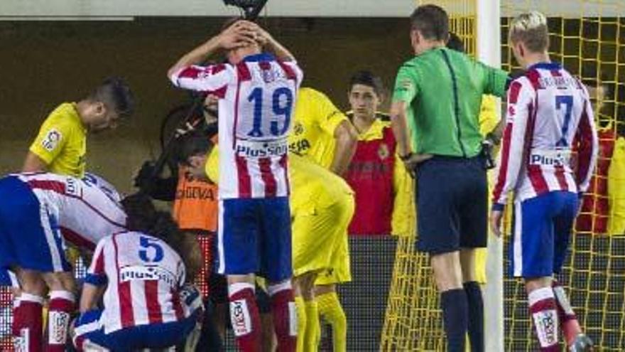 Los jugadores del Villarreal y del Atlético rodean a Asenjo tras la lesión.