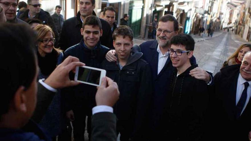 Rajoy se fotografía con unos jóvenes.