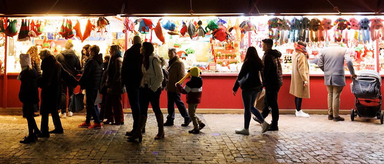 Varias personas en un mercado navideño.