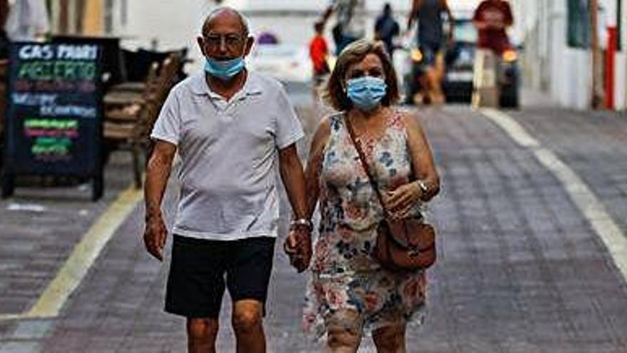 Una pareja pasea por el West End con las mascarillas puestas.