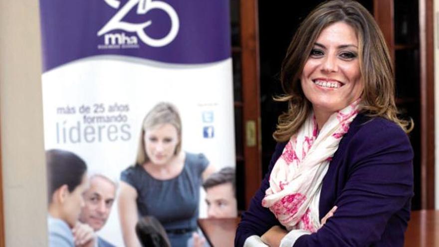 Judit García posa frente al cartel que celebra los 25 años de MBA Business School en Canarias.