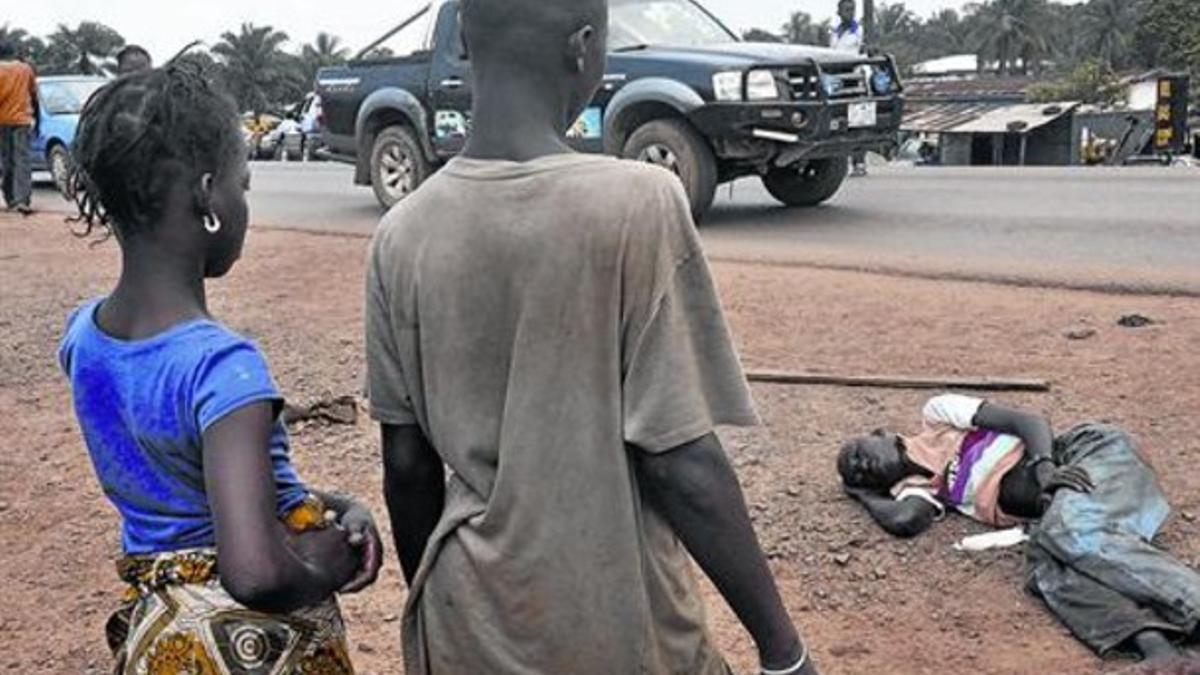 Un niño supuestamente enfermo de ébola yace en una calle de Monrovia, en Liberia.