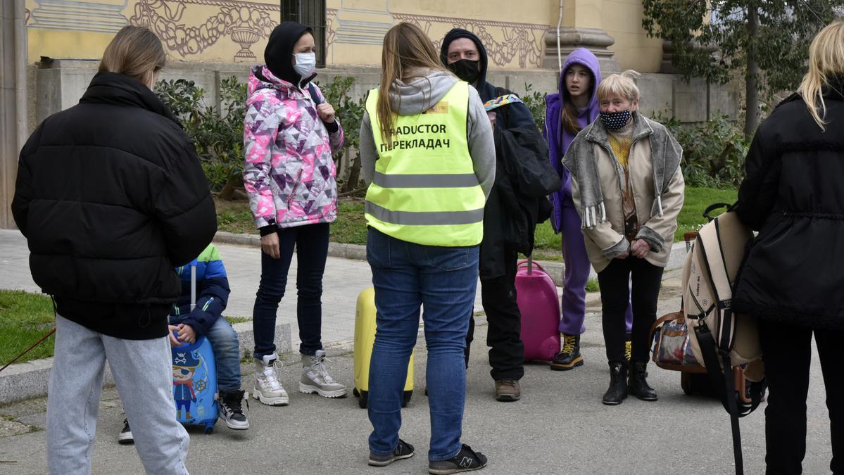 Refugiats parlen amb una traductora en arribar al centre habilitat a Barcelona