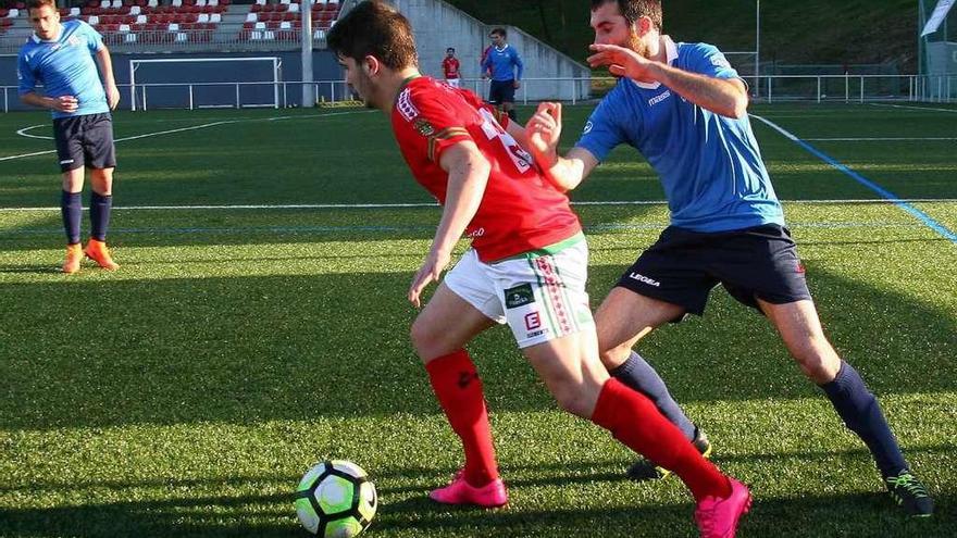 Arturo conduce el balón perseguido por un contrario en el Estradense-Erizana de ayer. // Bernabé/Adrián Rei