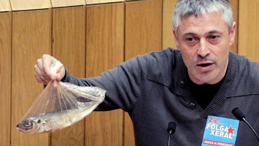 El diputado del BNG, Bieito Lobeira, muestra un jurel durante su intervención sobre la normativa comunitaria que limita su captura, esta tarde en el pleno del Parlamento de Galicia, en Santiago de Compostela.