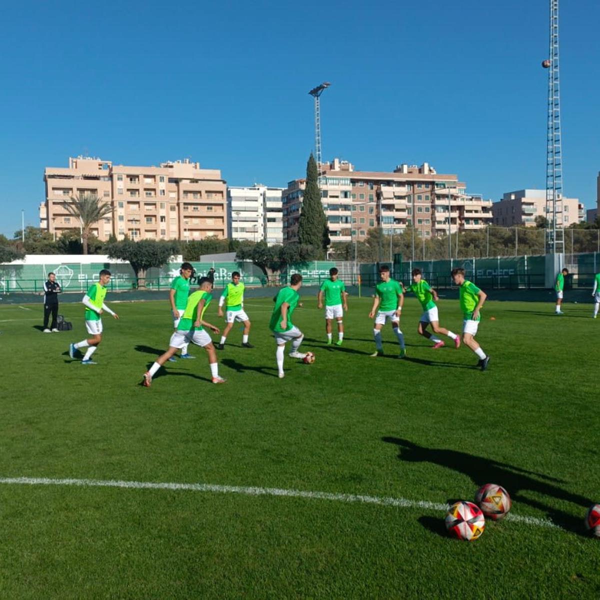 Los jugadores del Elche Juvenil, durante el calentamiento, antes del partido de este domingo frente al Alzira